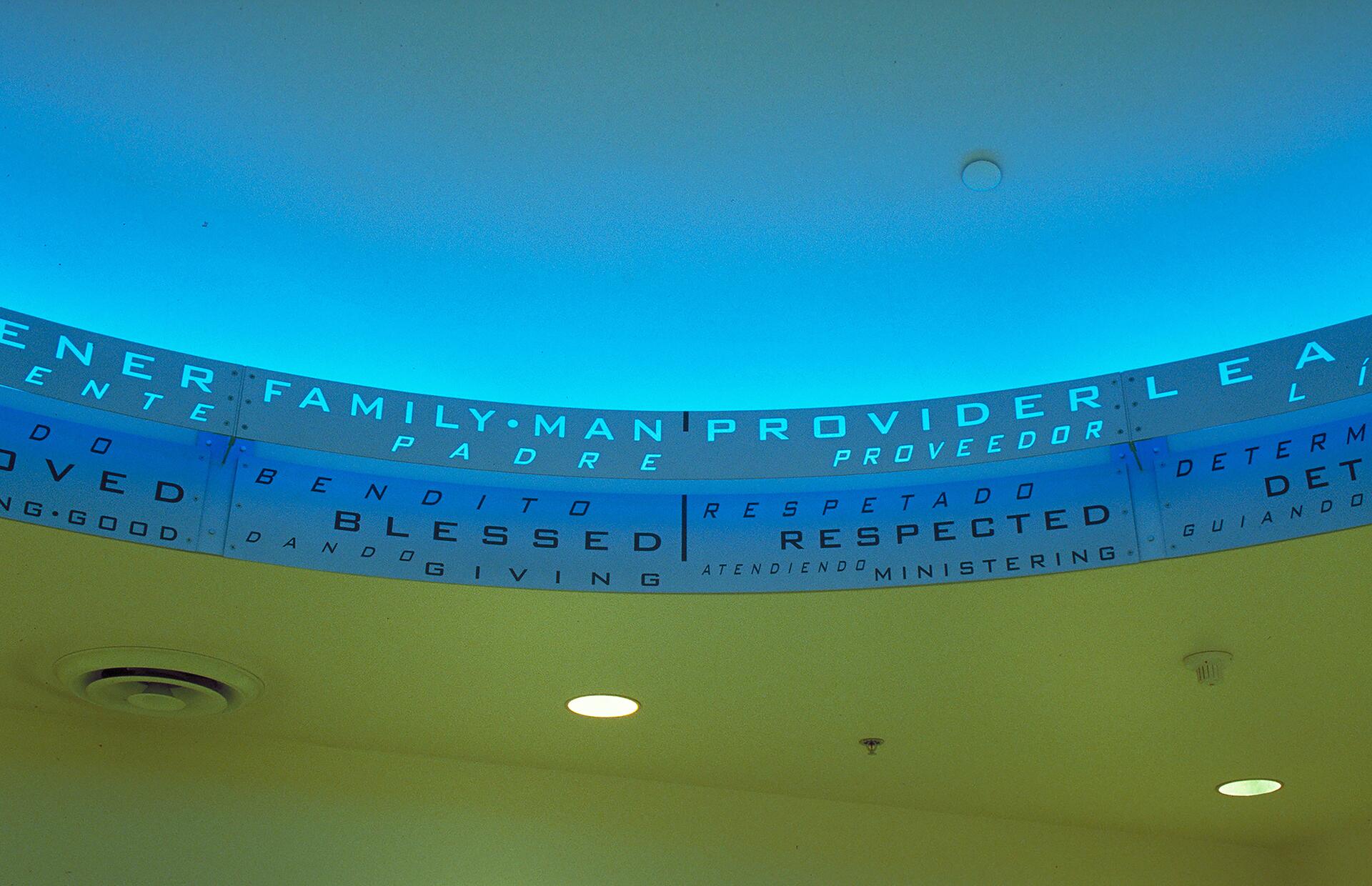 Ceiling with blue lighting featuring words like "Family Man," "Provider," and "Respected" in English and Spanish.