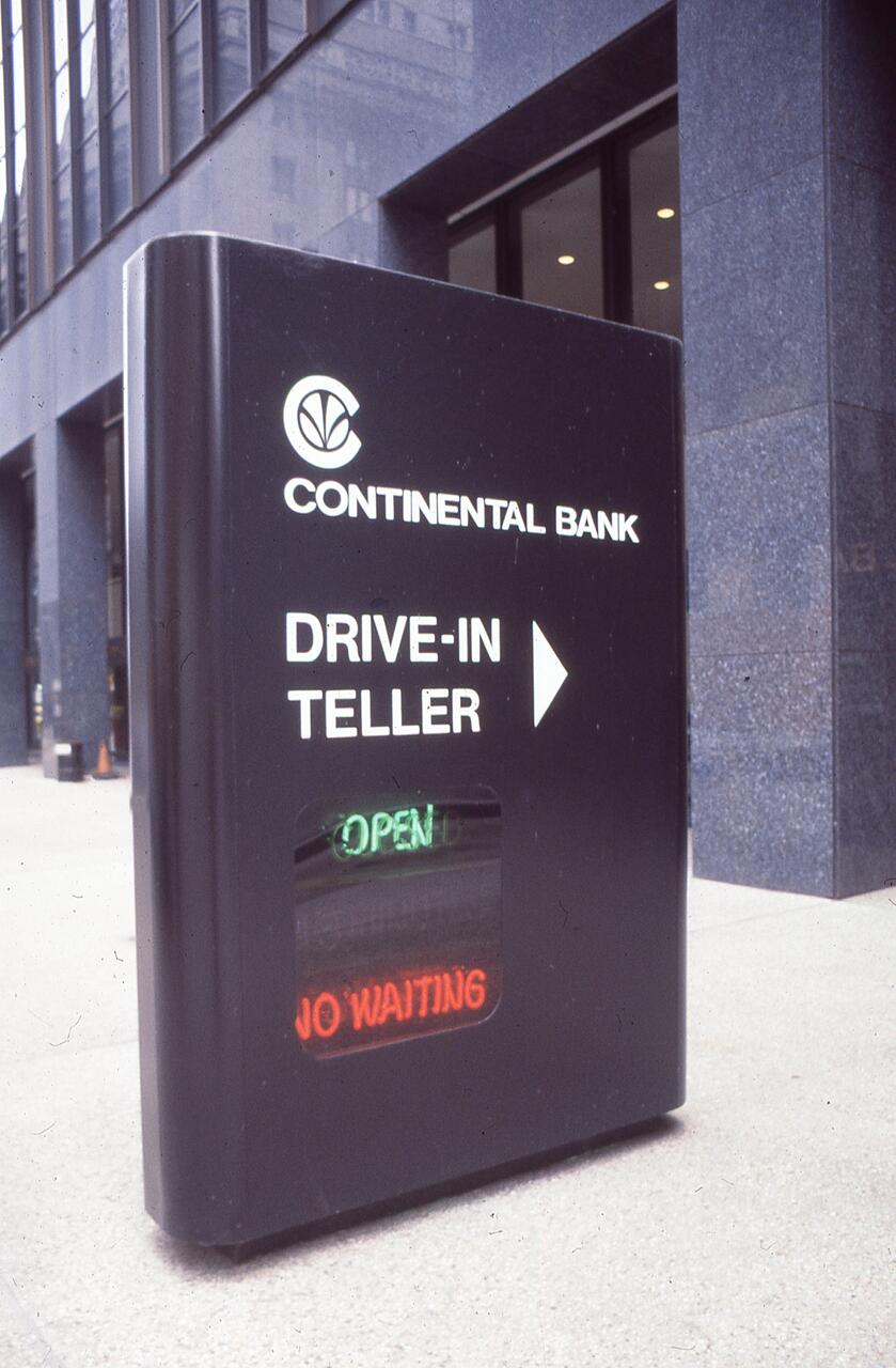 Sign outside a building reads "Continental Bank Drive-In Teller." It displays "Open" and "No Waiting" in green and red lights.