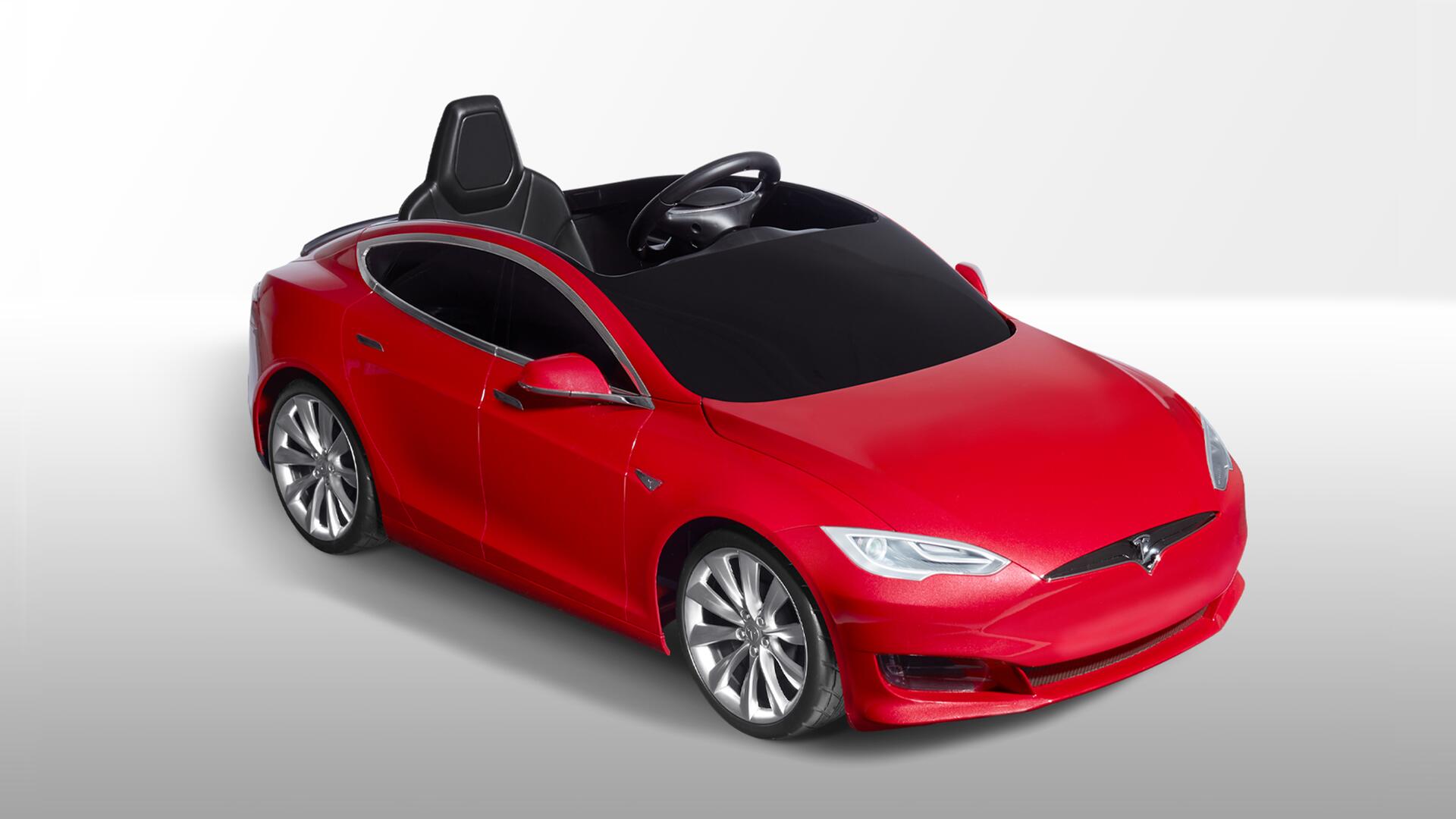 Red toy car resembling a modern sedan, with a sleek design, shiny finish, and visible steering wheel. Set against a white gradient background.