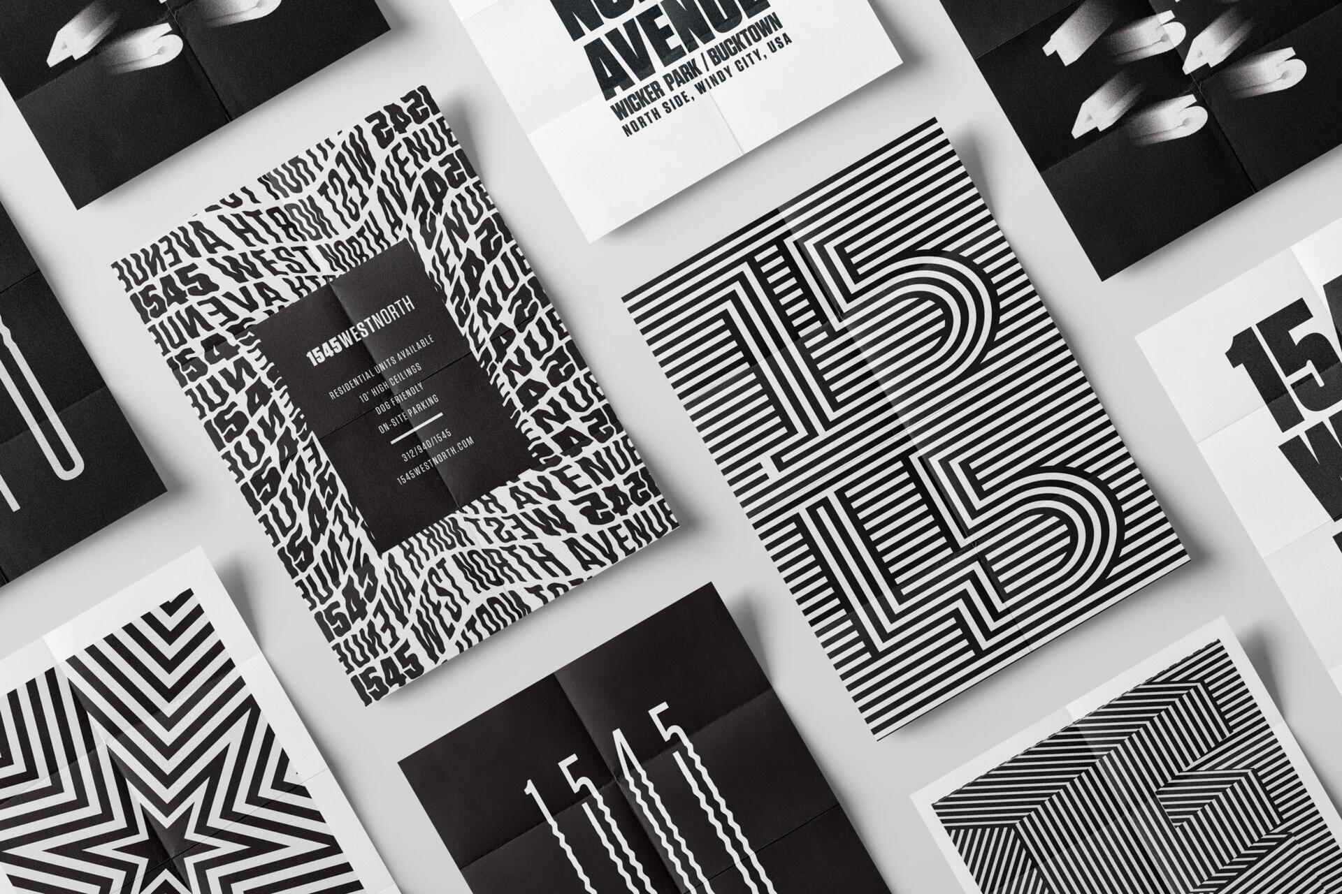 Black and white graphic designs with bold text and patterns, featuring large numerals and distorted lines on multiple pieces of folded paper arranged in a grid.