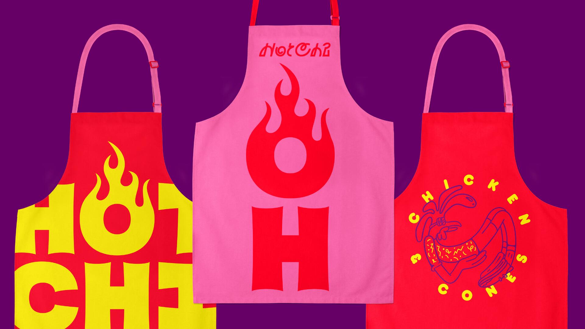 Three colorful aprons on a purple background. The left apron is red with large yellow text and a flame. The middle apron is pink with a red flame graphic. The right apron is red, featuring a blue chicken illustration and yellow text.