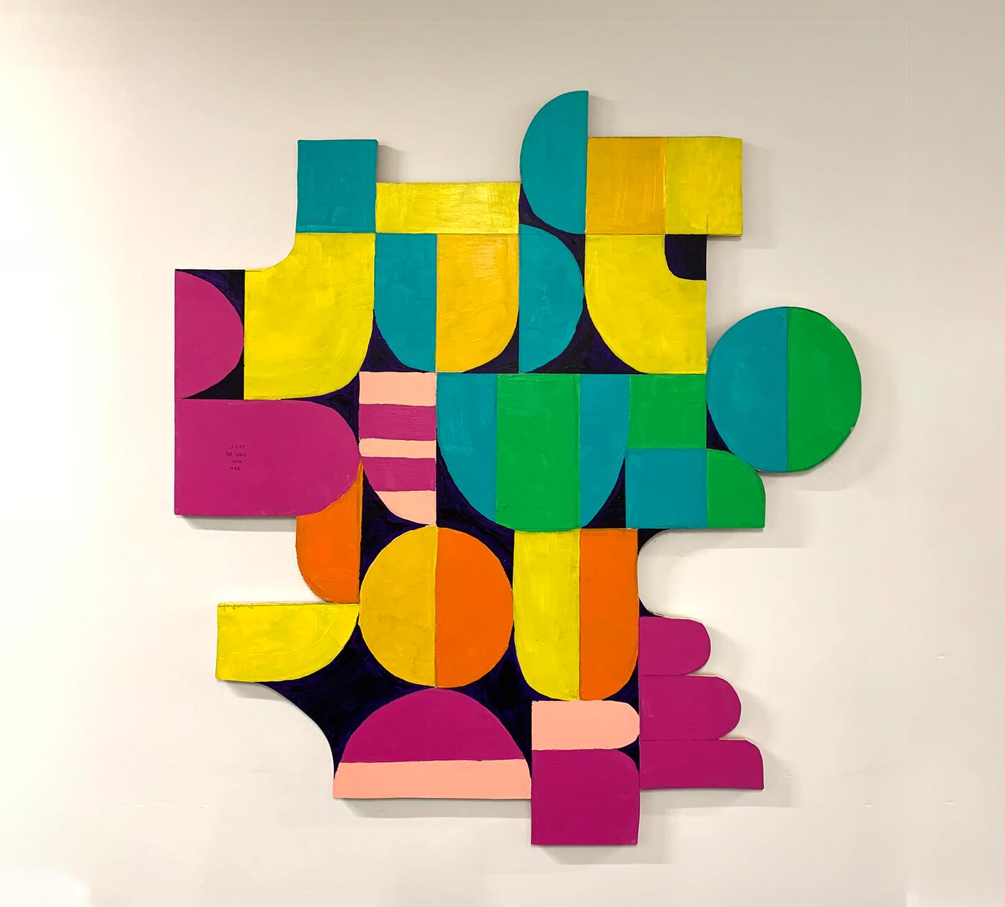 Colorful abstract wall art with overlapping geometric shapes, including circles and rectangles, in vibrant shades of blue, yellow, pink, and green.